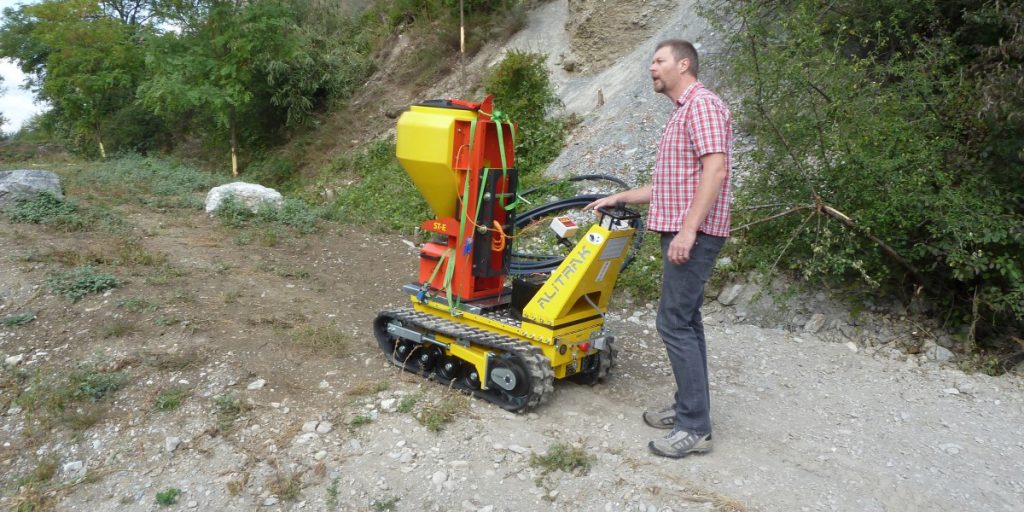 Electric carrier on crawlers transporting harvest bins through narrow vineyard rows with ease and efficiency.