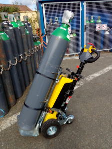 Alitrak AU LT300 Electric Tow Tug moving a trolley with oxygen tanks