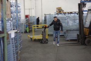 Alitrak AU LT300 Electric Pedestrian Tow Tug moving heavy trolley in a warehouse setting
