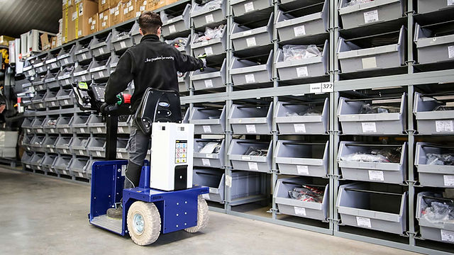 Operator driving Zallys K4 Industrial Electric Tow Tractor towing heavy items